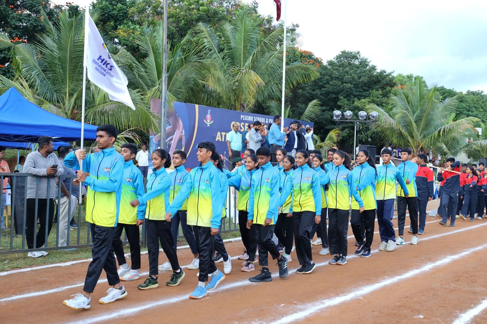 A visiting school's contingent behind its flag during the march past — CBSE Cluster VIII Athletics Meet, 2024.