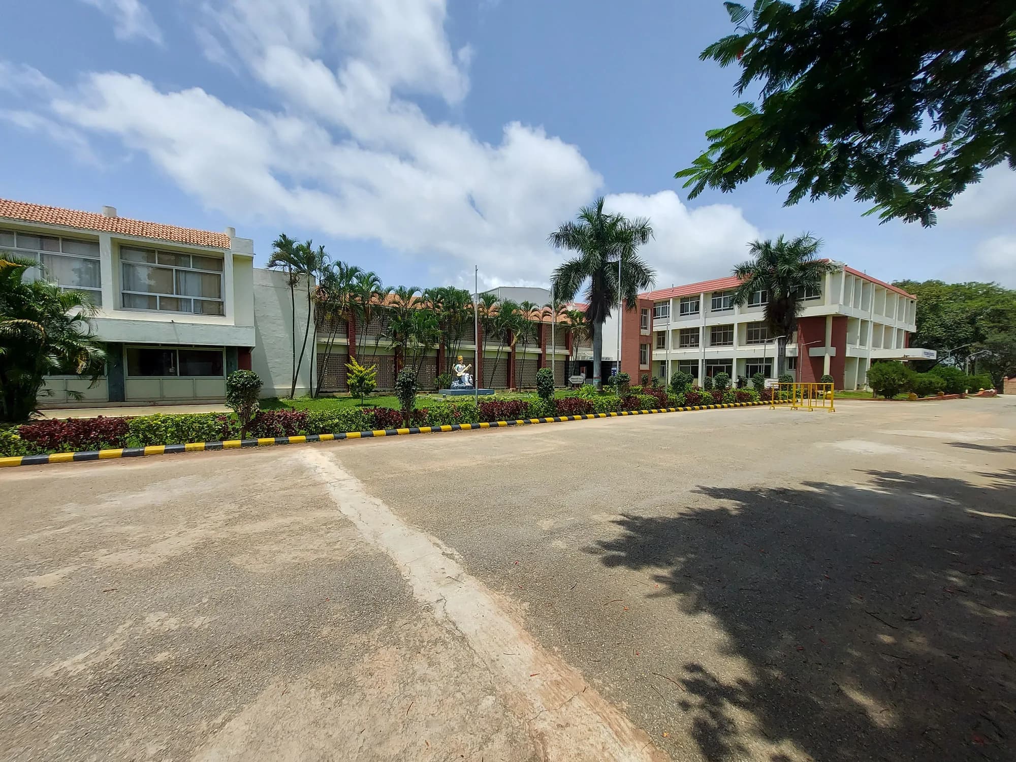 Two academic blocks at PSSEMR School, Davangere, with a Saraswati statue between them
