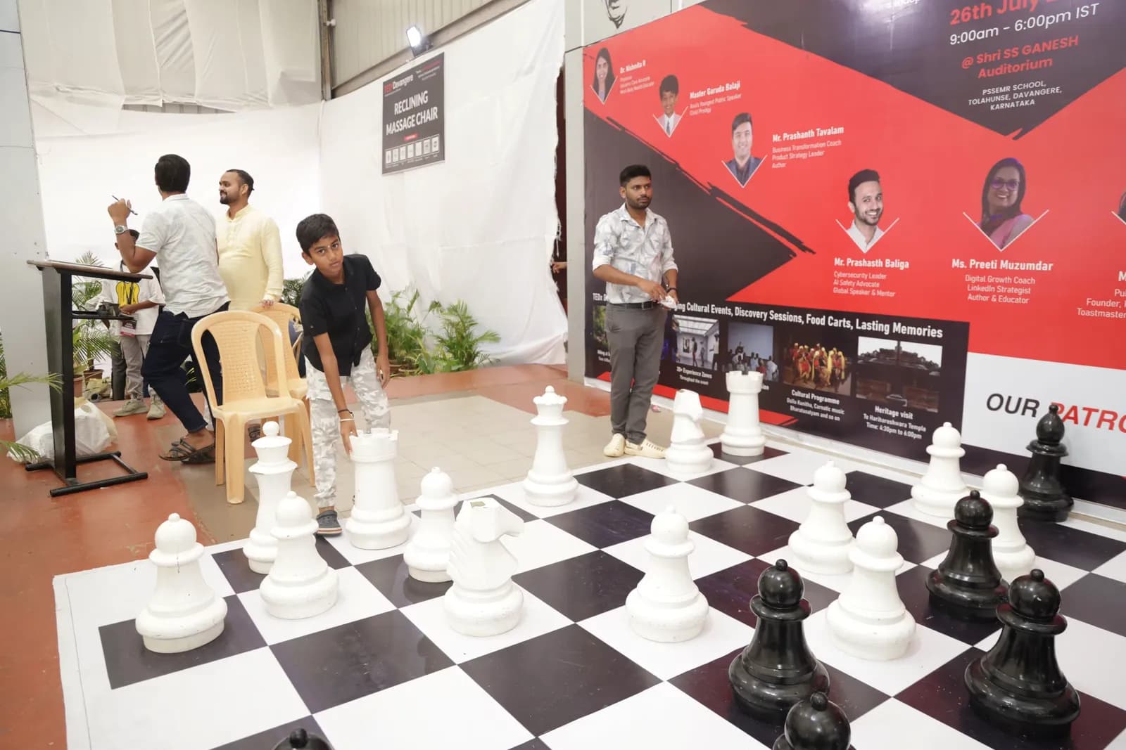 Giant floor chess beside the board listing the 2025 speakers