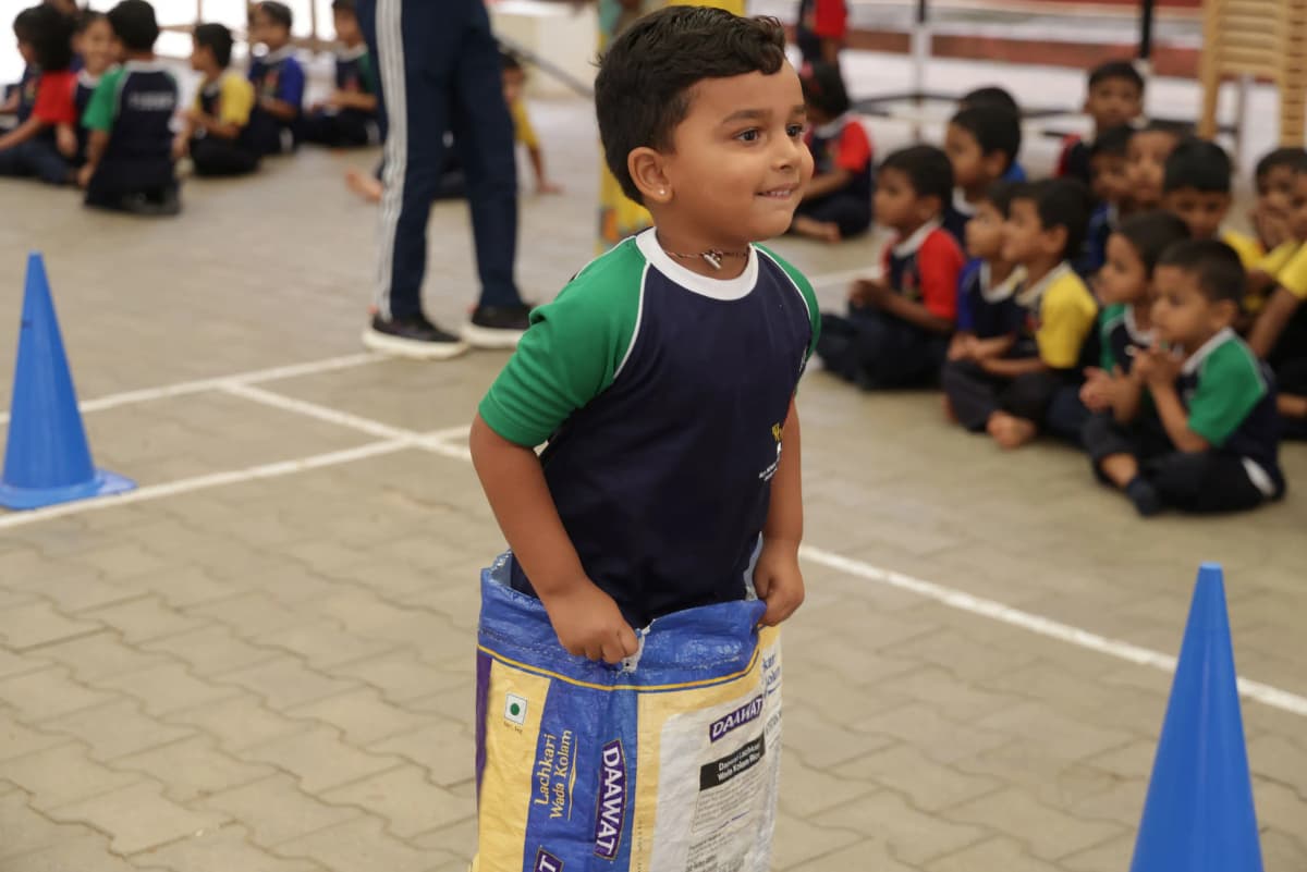 Teacher crouching beside a child to help with a table activity