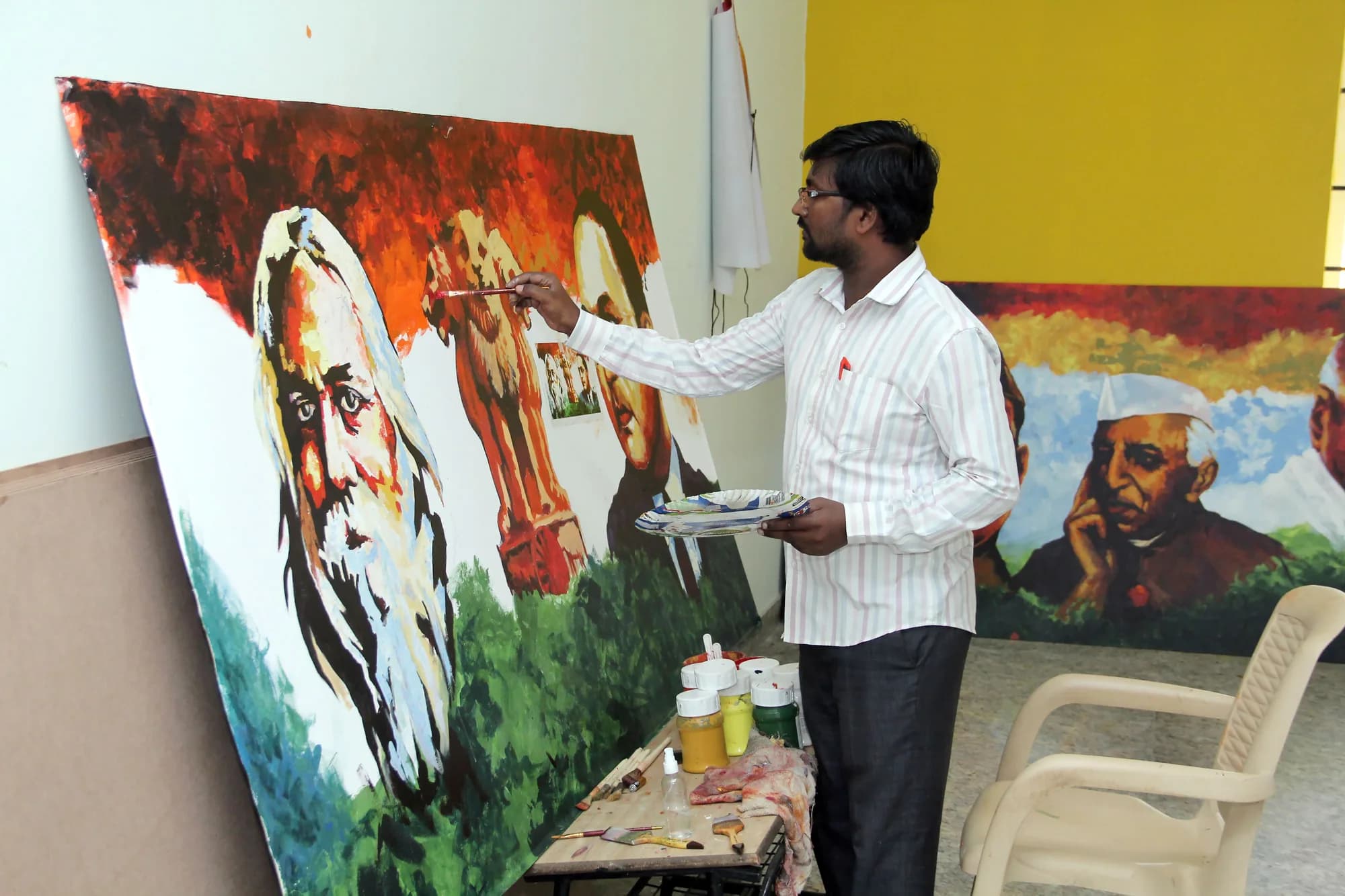 An artist at an easel painting a large canvas portrait of Rabindranath Tagore