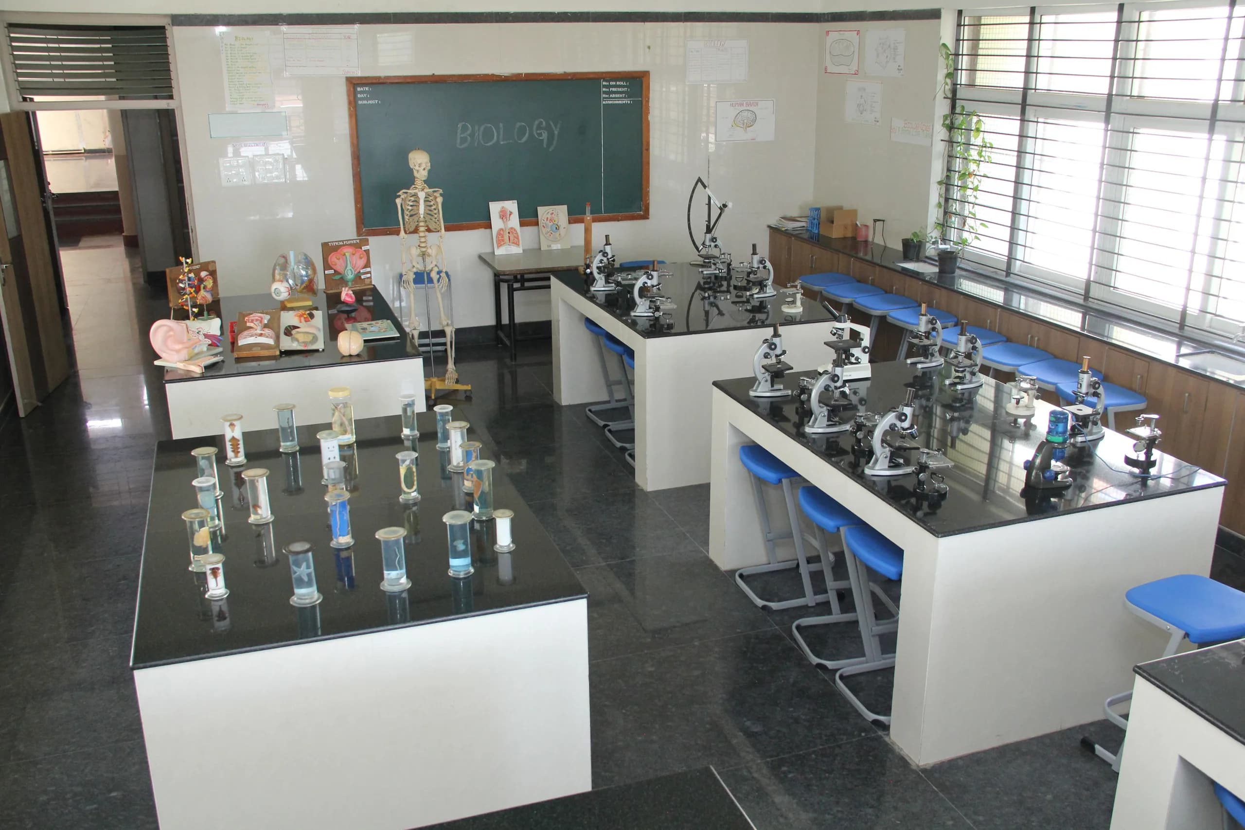 The biology laboratory at PSSEMR School, with rows of microscopes and anatomical models