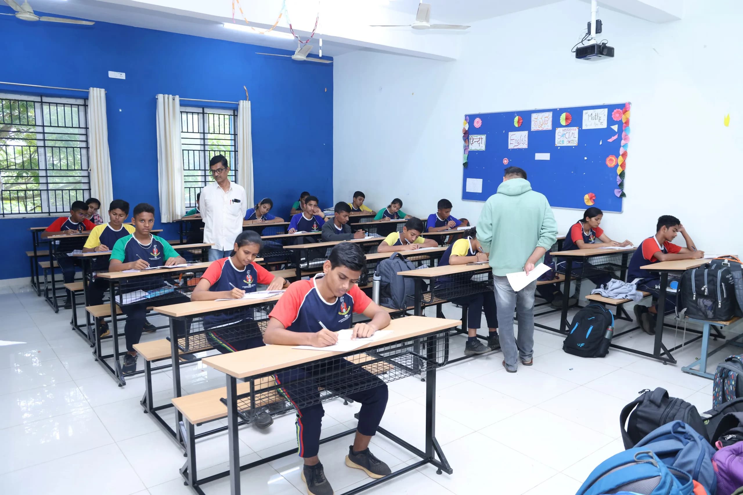 Students writing at their desks in a classroom at PSSEMR School