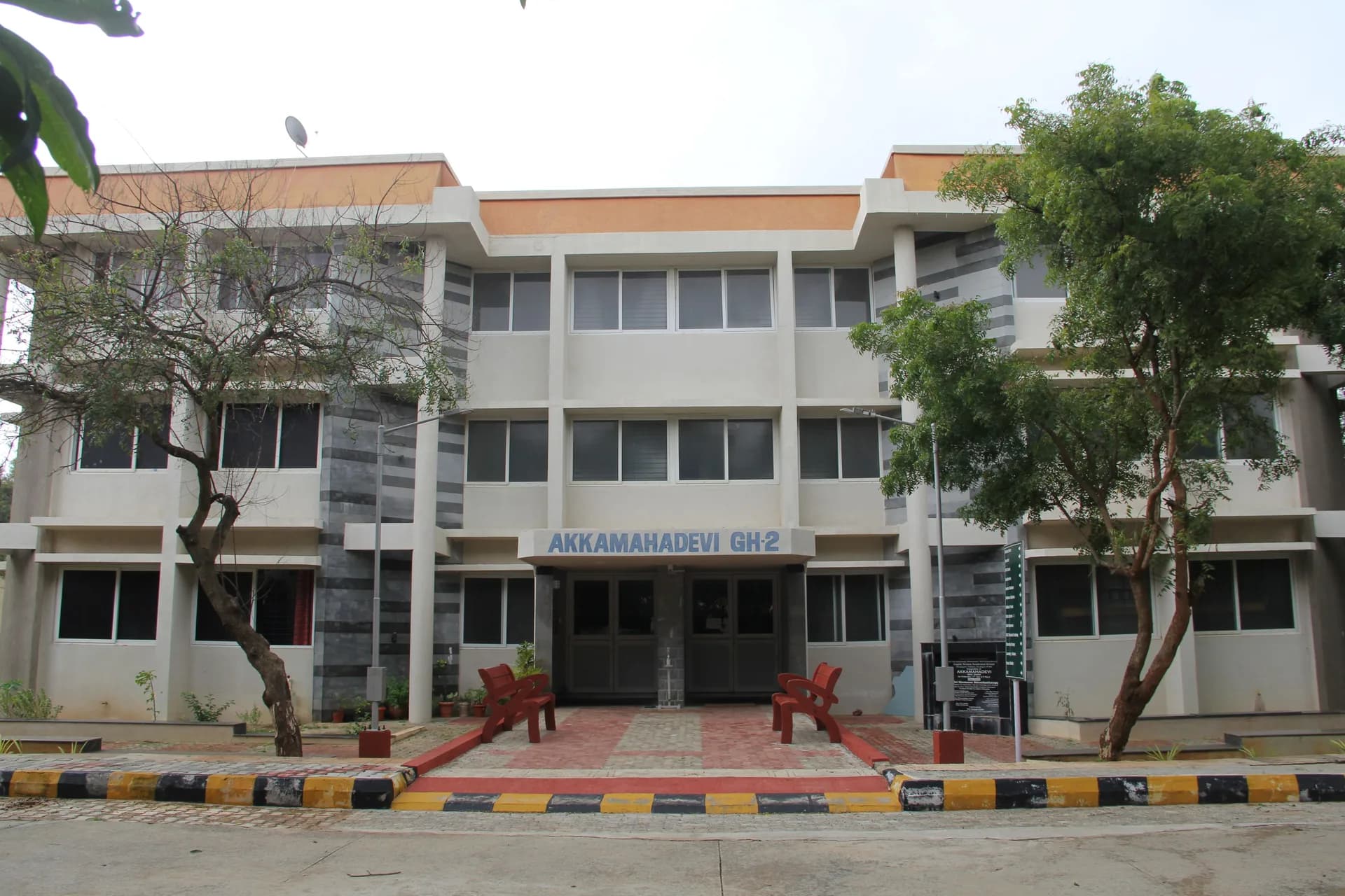 Girls' hostel block at PSSEMR School, with benches and trees along its frontage