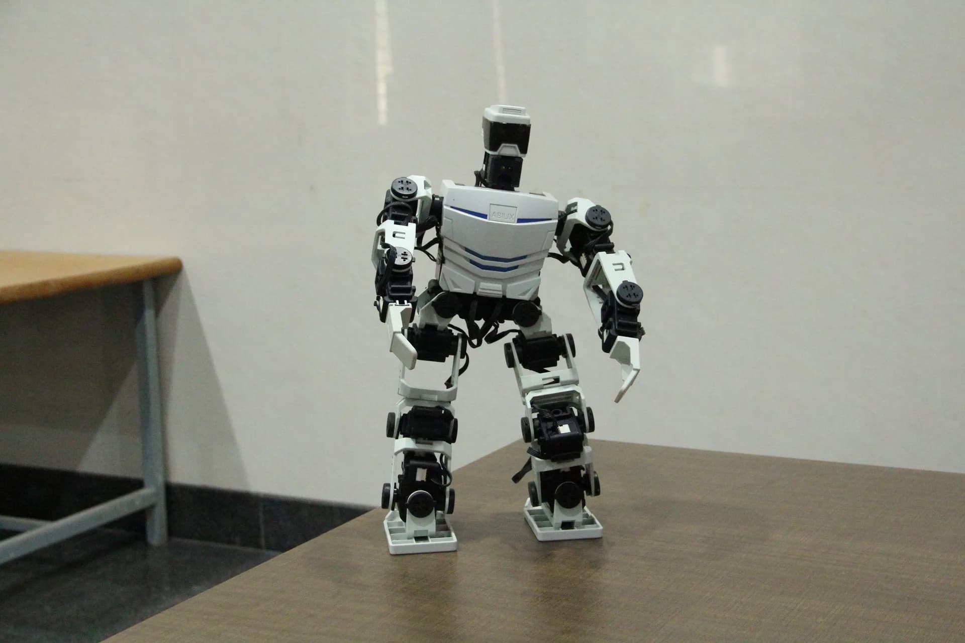 White humanoid robot on a desk in the PSSEMR School robotics room