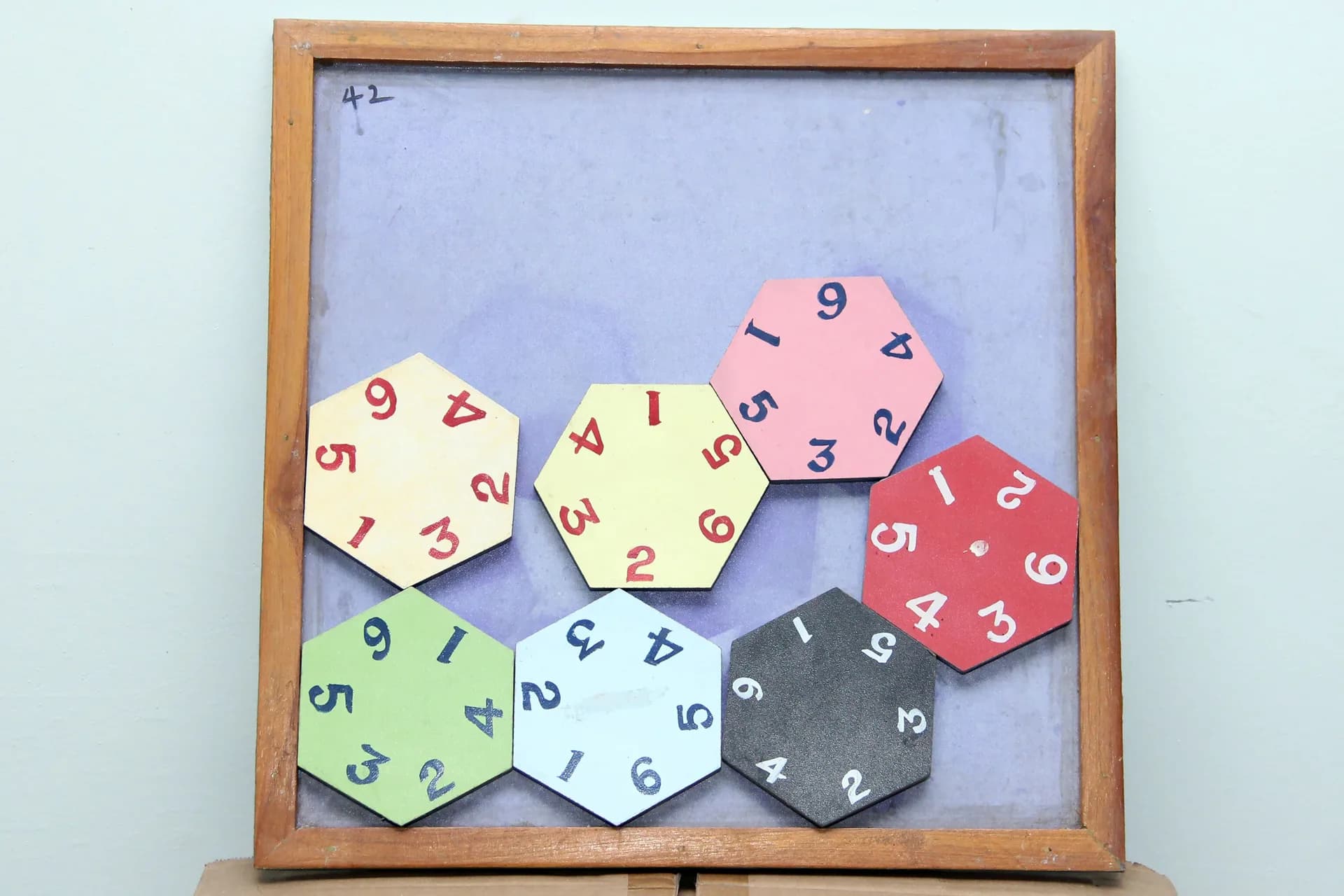 Framed board of coloured hexagonal tiles printed with numbers