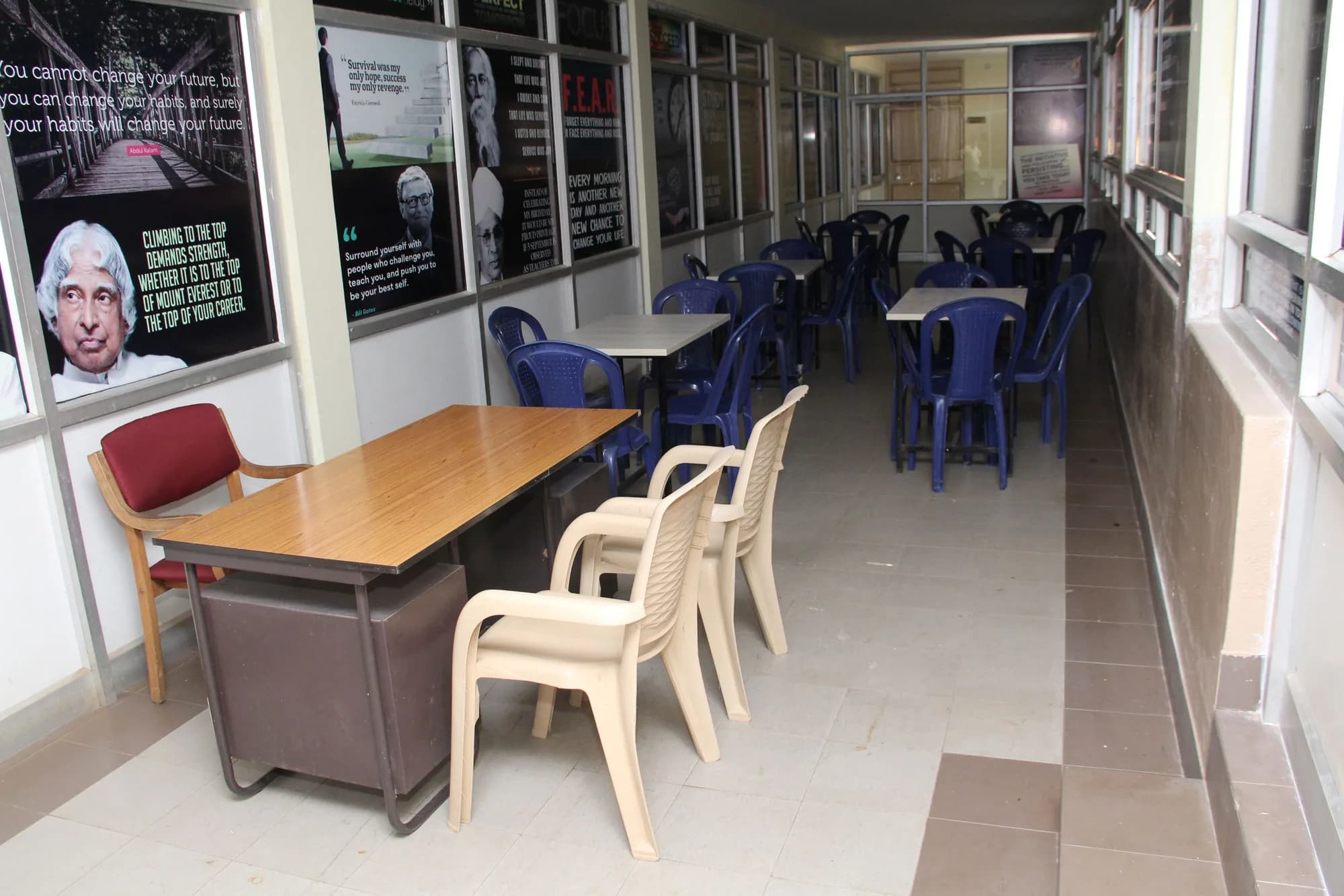 Narrow room lined with printed quotations above rows of blue chairs