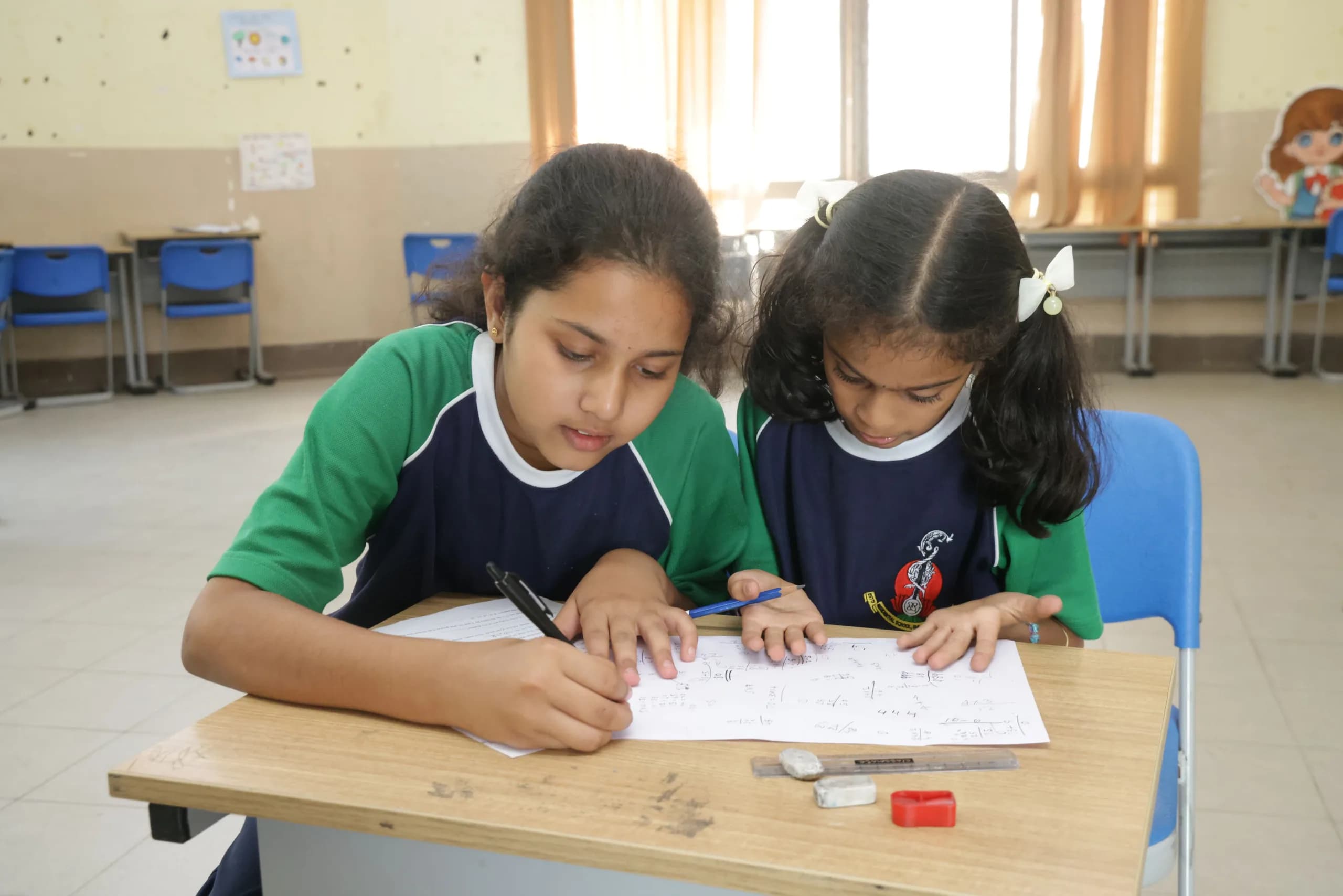 Two students working through a written worksheet together at PSSEMR School