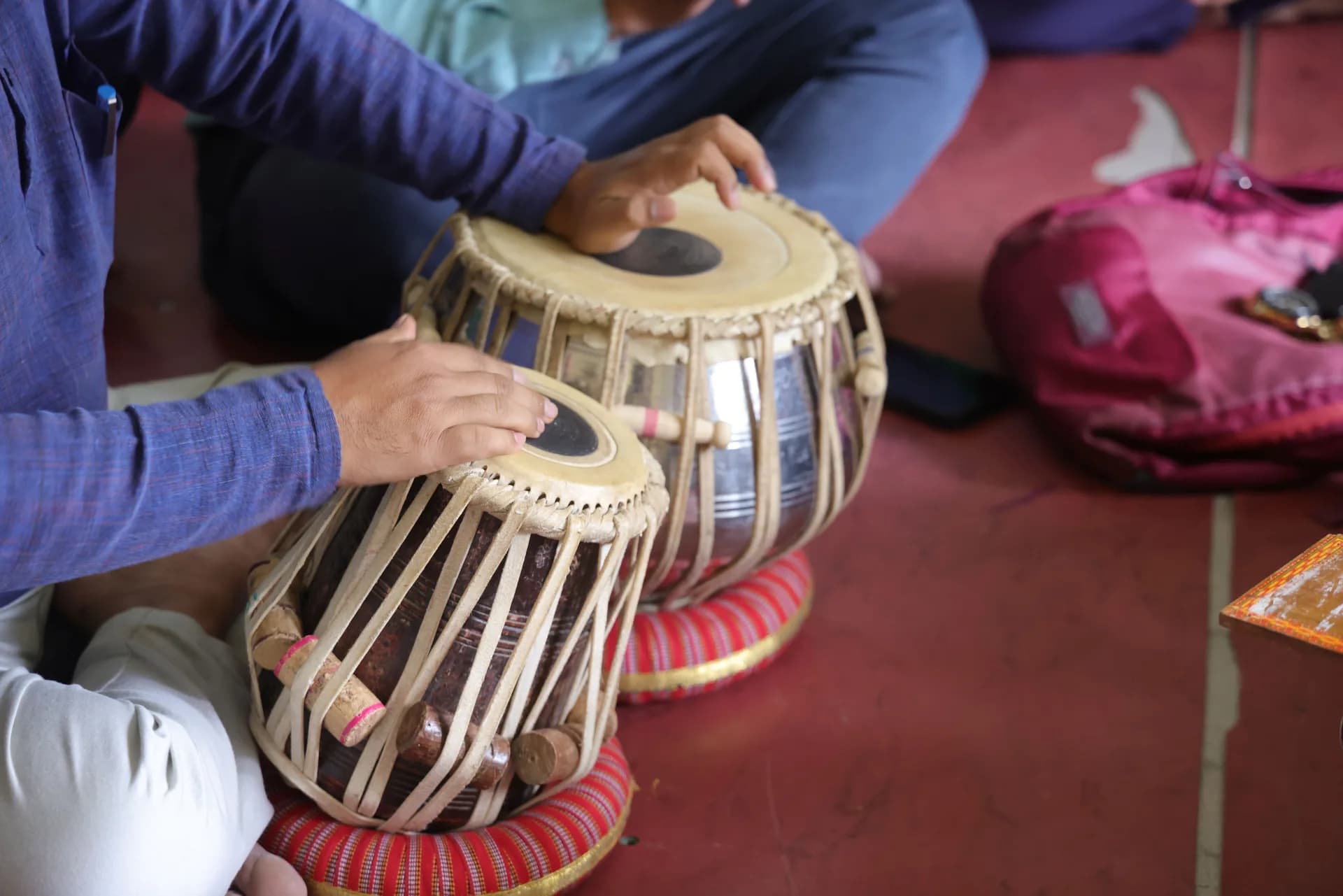 Both hands of a tabla player resting on the dayan and bayan drum heads